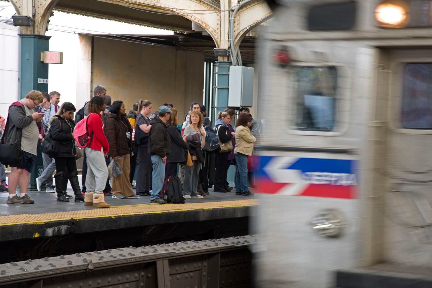 A Regional Rail train arrives as commuters wait on the platform at 30th Street Station during evening rush hour.