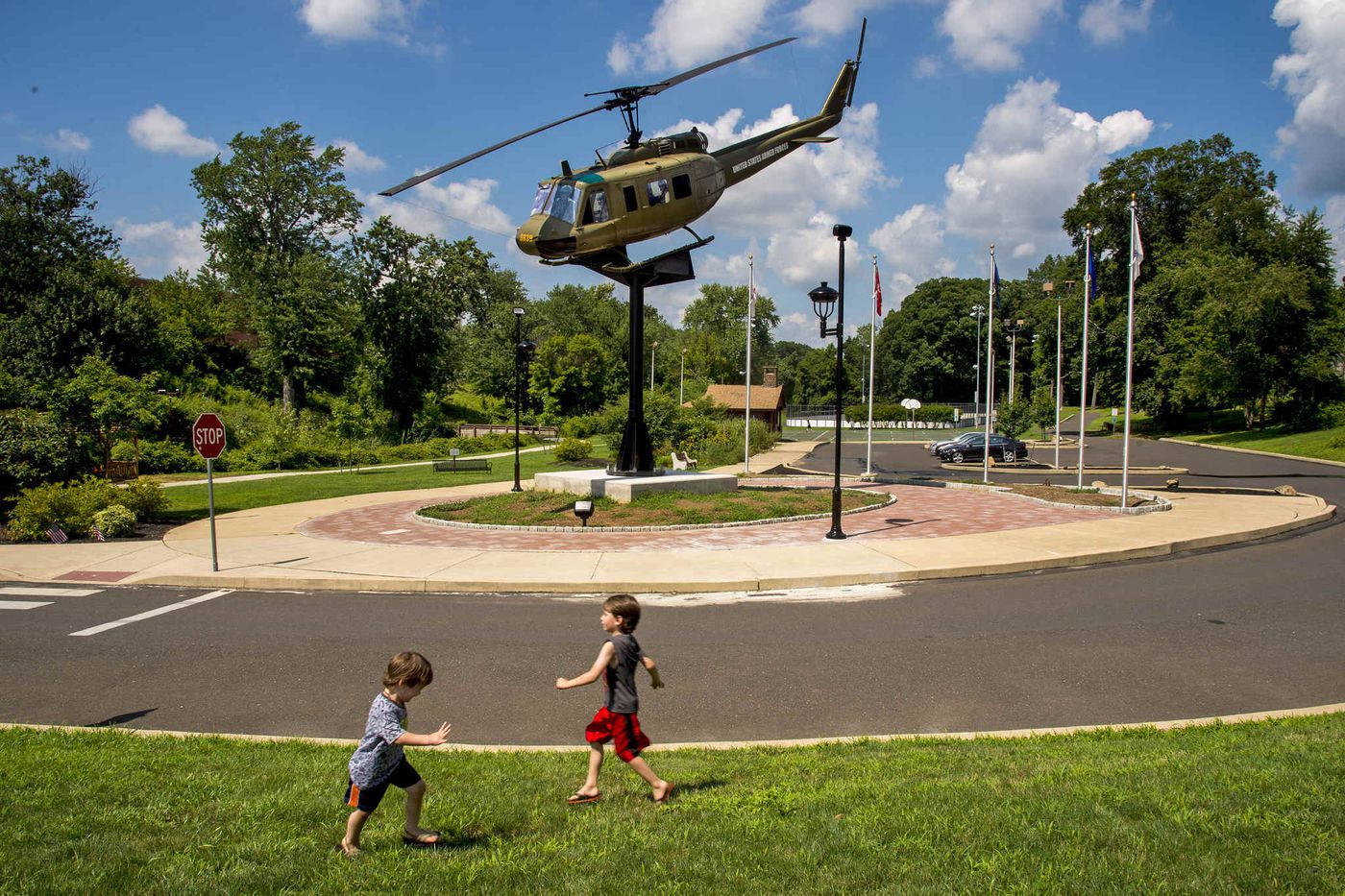 Noah (left, 3) and Nate Kolsky, 5, pretend to be airplanes, playing near the memorial.
